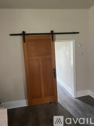 A wooden door with a black handle and a black bar above it.