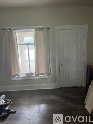 A room with a window and a door is available for rent.