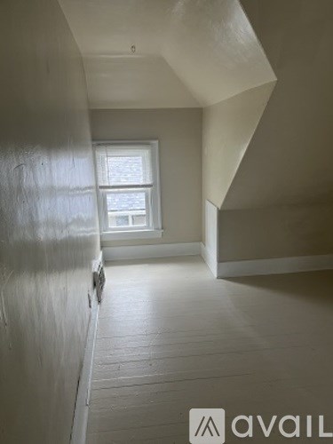 A room with a window and wooden flooring.