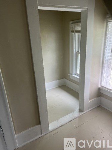 A room with a window and a door is available for rent.
