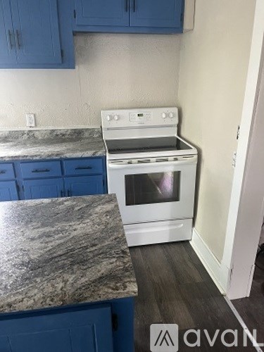 A white stove top oven sitting on a granite counter top.