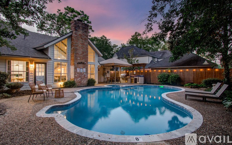 A backyard with a pool and a house.