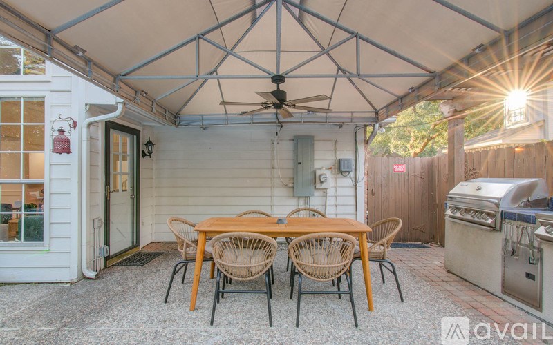 A patio with a table and chairs under a white canopy.