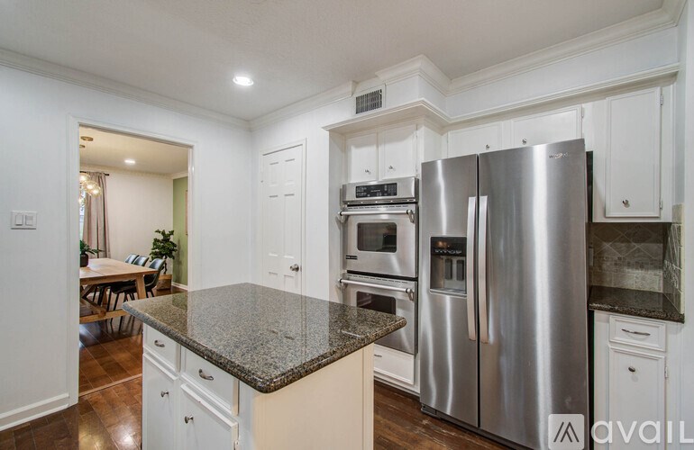 A kitchen with a granite countertop and stainless steel appliances.