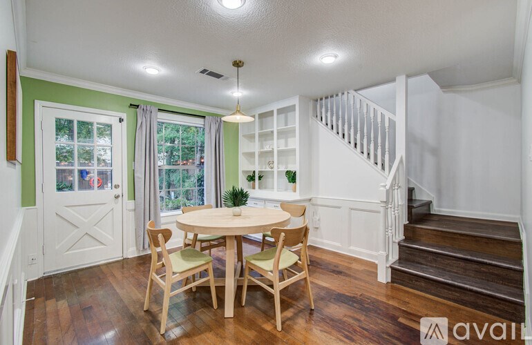 A dining room with a round table and chairs.