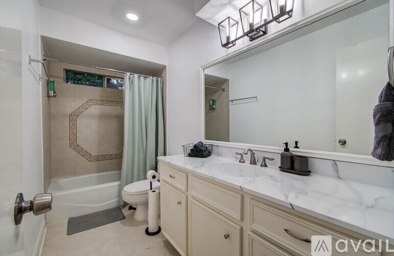 A bathroom with a toilet, sink, and shower.