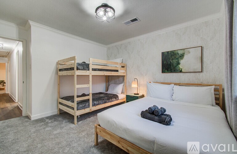 A bedroom with a large bed and a bunk bed.