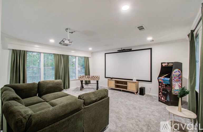A living room with a green sofa and a flat screen TV.