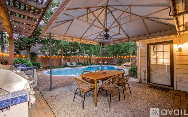 A patio with a table and chairs under a canopy.