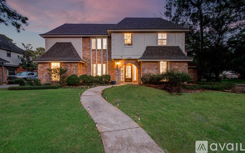 A house with a well-manicured lawn and a pathway leading to the front door.