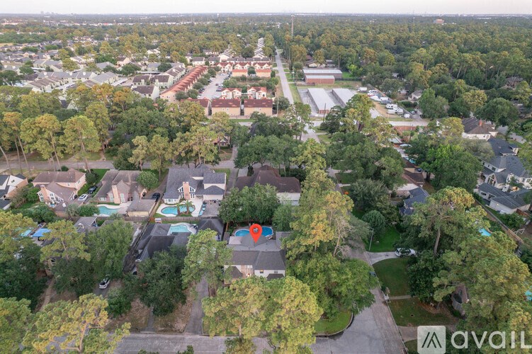An aerial view of a residential area with a swimming pool and trees.