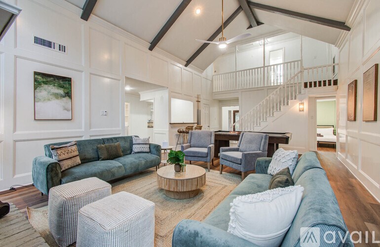 A living room with a staircase in the background.