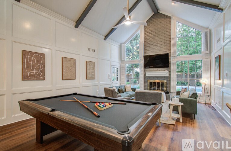A pool table is in the middle of a room with a fireplace and a couch.