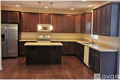 A kitchen with dark wood cabinets and a stainless steel refrigerator.