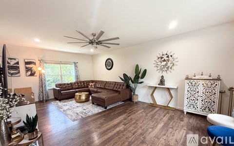 A living room with a brown sofa and a white cabinet.