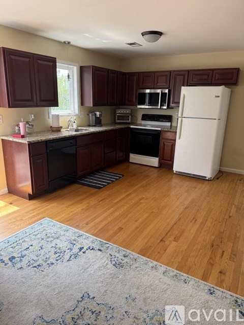 A kitchen with wooden cabinets and a white refrigerator.
