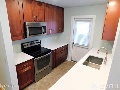 A kitchen with brown cabinets and a black stove top oven.