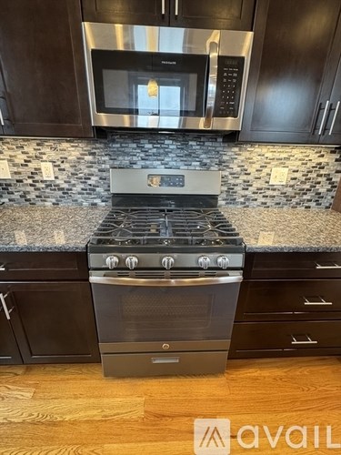 A modern kitchen with a black oven and microwave above a counter.
