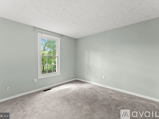 A room with a window and carpeted floor.