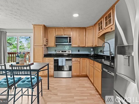 A kitchen with wooden cabinets and a black countertop.