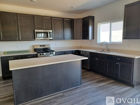 A modern kitchen with dark brown cabinets and a white island.