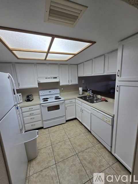 A kitchen with white cabinets and appliances.