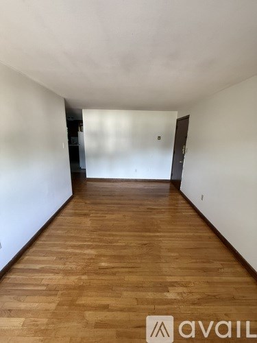 A long hallway with wooden floors and white walls.