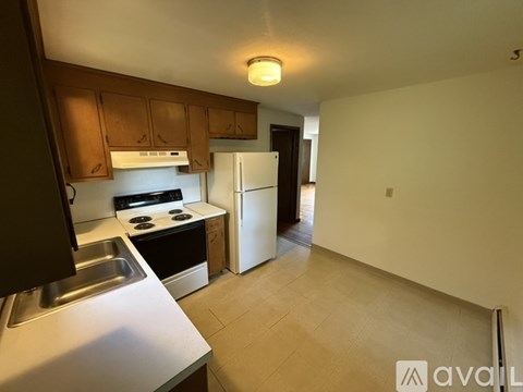 A kitchen with a stove, sink, and refrigerator.