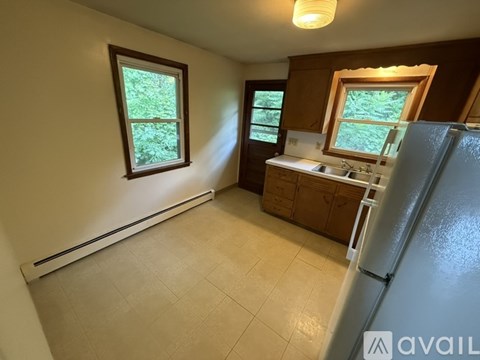 A kitchen with a refrigerator, sink, and cabinets.