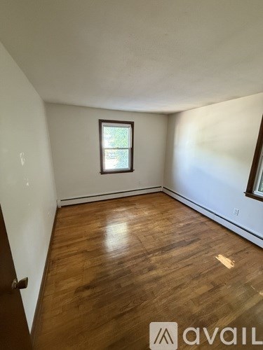 A room with wooden flooring and a window.