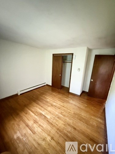 A room with wooden floors and two doors.