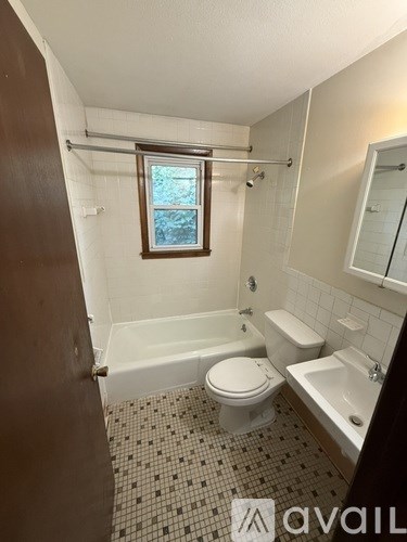 A bathroom with a toilet, sink, and bathtub.