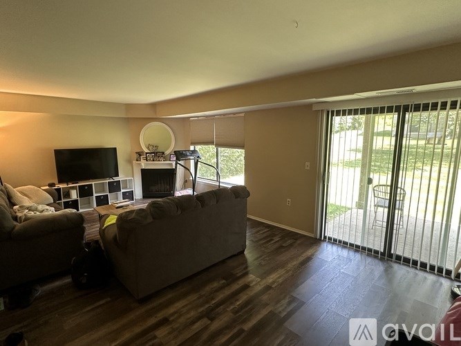 A living room with a couch, chair, and television.