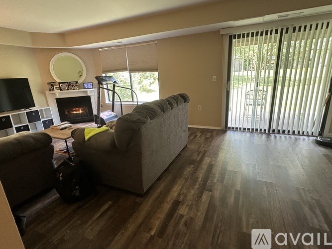 A living room with a grey couch and a fireplace.