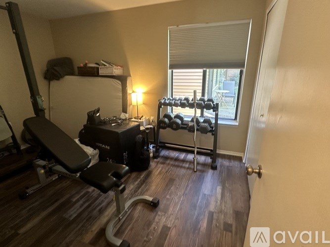 A home gym with a bench, weights, and a treadmill.