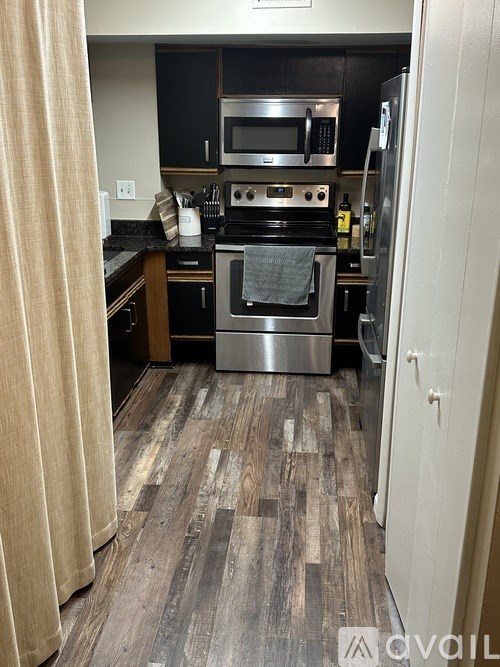 A kitchen with a stove top oven and a refrigerator.