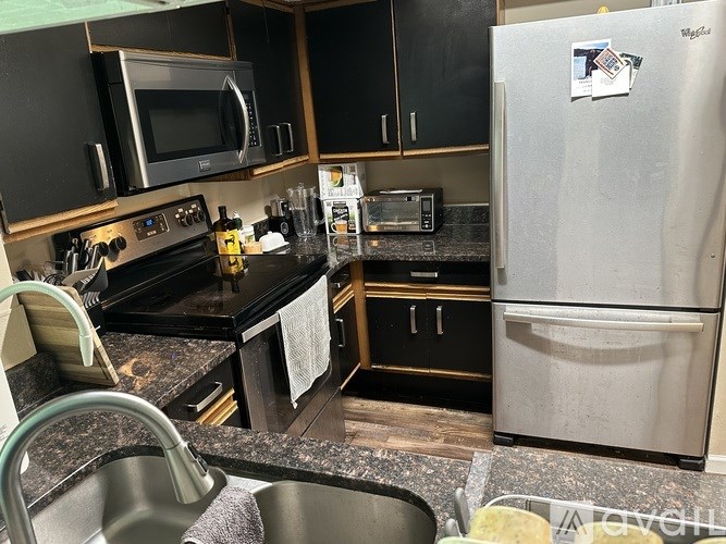 A kitchen with a stove top oven, microwave, and refrigerator.