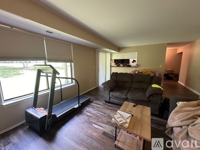 A living room with a treadmill, a couch, and a coffee table.