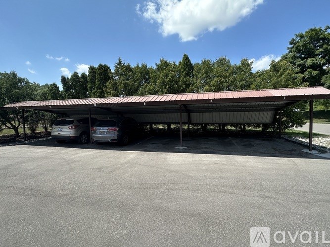 A covered parking area with two cars parked inside.