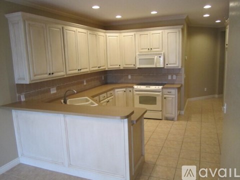 A kitchen with white cabinets and a countertop.