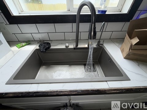 A kitchen sink with a faucet running water into it.