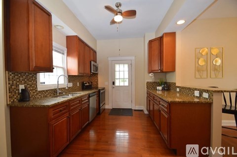 A kitchen with brown cabinets and a tiled backsplash.