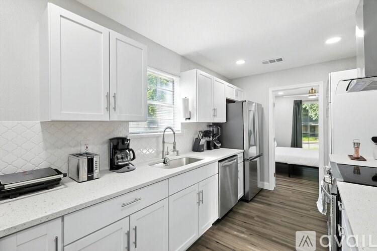 A kitchen with white cabinets and a white countertop.