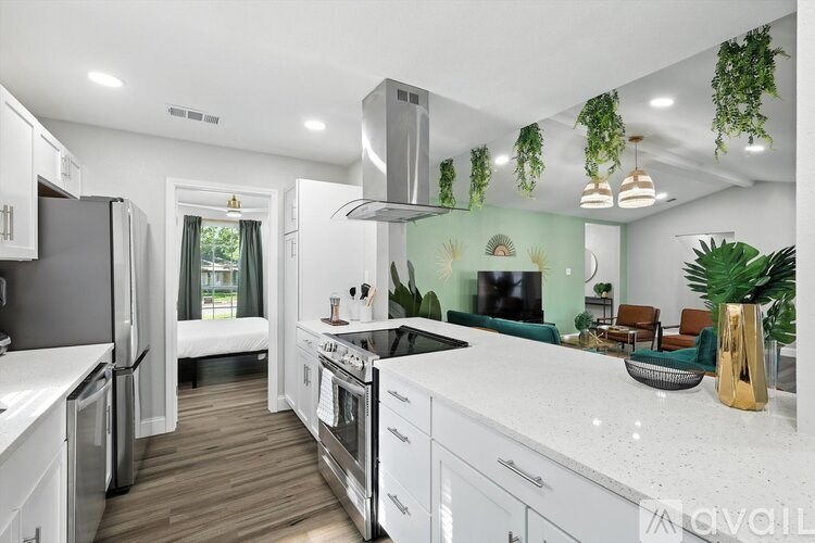 A modern kitchen with white cabinets and stainless steel appliances.