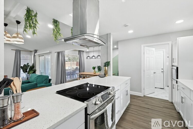 A modern kitchen with a large island and a stainless steel range hood.