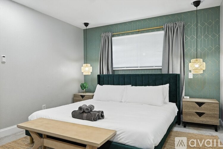 A bedroom with a bed, nightstands, and a window with curtains.