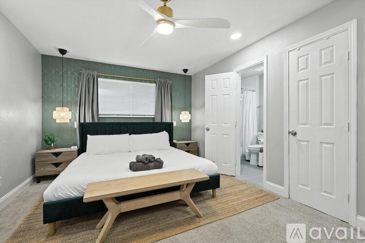 A bedroom with a large bed and a wooden coffee table.