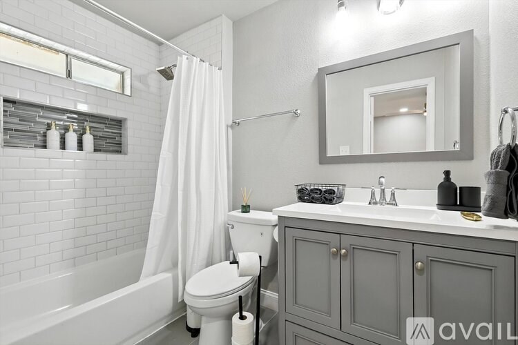 A bathroom with a white tub, toilet, and sink.