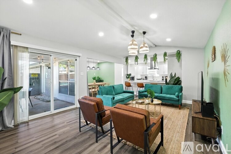 A living room with a green couch and a brown chair.