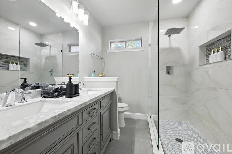 A bathroom with a marble countertop and a walk-in shower.
